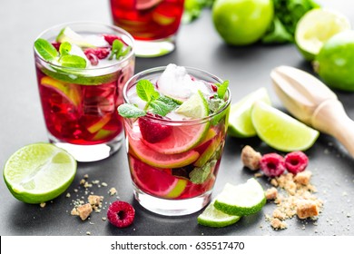 Raspberry mojito cocktail with lime, mint and ice, cold, iced refreshing drink or beverage - Shutterstock ID 635517470