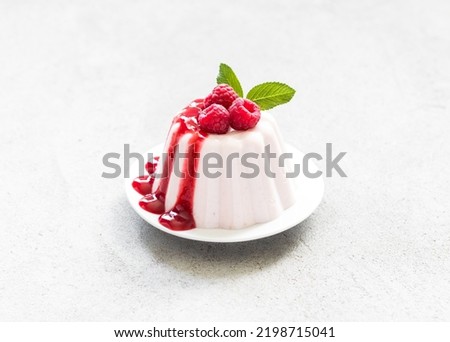 Raspberry Panna Cotta with sauce, on a plate. Light gray background