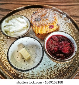 Raspberry Scone With Butter, Cream And Raspberry Jam On The Plate.