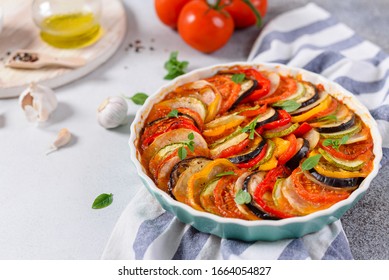 Ratatouille Casserole On White Background. Colorful Layers Of Fresh Summer Vegetables: Zucchini, Eggplant, Tomatoes And Potatoes. Healthy Vegan, Vegetarian Dish. Copy Space For Text. Menu, Recipe