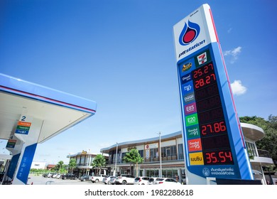 Ratchaburi, Thailand : May 29,2021-Electrical signboard of fuel oil price at PTT gas station with commercial buildings and clear sky in background