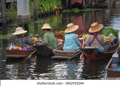 Ratchaburi, Thailand - September 18, 2020 : Peoples sell Thai cuisine on wooden boat at Damnoen Saduak Floating Market the tourists visiting by boat is popular tourist attraction on canal Thailand.