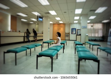 Ratchaburi, Thailand:April 10, 2018 - A Girl Is Waiting For Her Queue In The Branch Office Of Bank With Empty Chairs Around