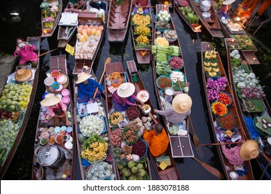 RATCHABURI, THAILAND-NOVEMBER 15 , 2020 : Unidentified vendors give alms to monks due to Buddhism at Khlong Damnoen Saduak, a famous old floating market popular with both Thai and foreign tourists.