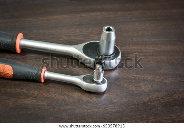 ratchet (socket) wrench lying on wooden background\
with copy space for\
text