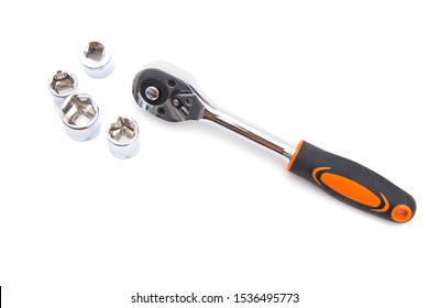 Ratchet wrench with black and orange handles with set of heads for it, isolated over a white background. Tools and hardware for everyday. Construction and repair. Copy space. Selective focus