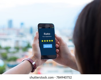 Rate Your Experience Five Star Concept.Female Hands Holding Mobile Phone On Blurred Urban City As Background