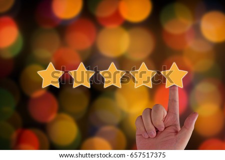 Rating and evaluation concept.  hand and five yellow star on blur background