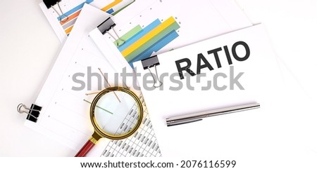 RATIO text on white paper on light background with charts paper