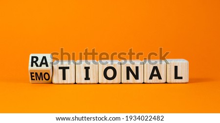 Rational vs emotional symbol. Turned wooden cubes and changed the word 'rational' to 'emotional'. Beautiful orange background. Business, psychological and rational vs emotional concept. Copy space.