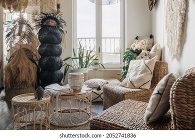 Rattan armchair with cushions near bamboo coffee table in bright living room with boho interior design. Concept of home decor and comfortable furniture in showroom - Powered by Shutterstock