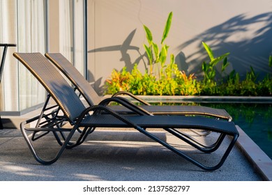 rattan bench standing next to swiming pool with small garden freshness environment background,relax casual home interior design concept