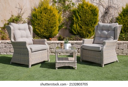 Rattan Chairs And A Table Outdoors.
