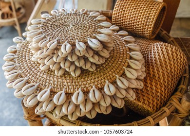 Rattan round table mats decorated with shells and rattan bottle holders at a street shop. Bali, Indonesia.