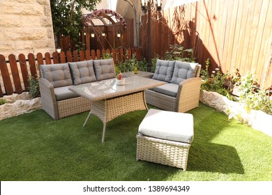 Rattan Sofas, Plastic And Wood, In An Old Green Garden