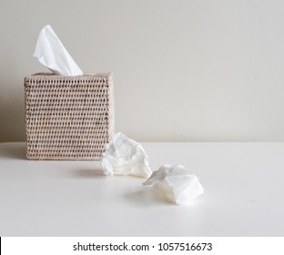 Rattan tissue box and crumpled tissues on table - cold and flu season concept, grief, concept (selective focus) - Shutterstock ID 1057516673