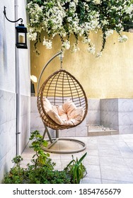 Rattan Wicker Cocoon Garden Swing Chair Hanged On Frame. Recreation Scene With A Hammock-chair In The Backyard Of The House. A Cozy Place To Relax. Relax Concept With Hammock Chair In Room.