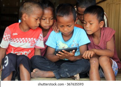 Raub, Malaysia - 24 JANUARY 2016: Aborigine Kids Are Watching Something From Mobile Phone. Technology Is Totally A New Thing For Rural Area People. 