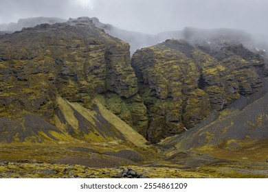 Raudfeldsgja Gorge foggy landscape with vertical cliffs covered with moss and a narrow crack, Botnsfjall Mountain, Snaefellsnes peninsula, Iceland.  - Powered by Shutterstock