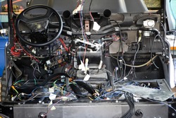 A lot of ravel multicolored wires from the car wiring lies in the cabin of dismantled car with connectors and plugs, a view through the window inside the battered car. Auto service industry, an Industrial Photo by Aleksandr Kondratov