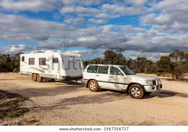 Raventhorpe, Australia - Mar 14,2021:
A large white caravan and modern 4WD vehicle free camp in the
outback at the old abandoned mining township of
Kundip.