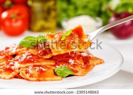 Ravioli pasta meal from Italy eat for lunch dish with fork and tomato sauce on a plate