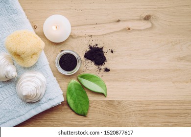 Raw Activated Charcoal Powder In Glass Jar And Natural Green Leaves Next To It, Seashells, Natural Sea Sponge And Bath Towel. Charcoal In Beauty Products Concept. Lot Of Copy Space.