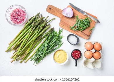 Raw asparagus eggs and french dressing ingredients with dijon mustard, onion chopped in red vinegar taragon on white textured background, top view.