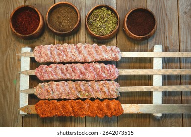 Raw assorted Azerbaijani kebabs prepared for grilling. Traditional minced and marinated meat skewers, ready for barbecue. Authentic Caucasus cuisine with lamb, beef, and chicken varieties.