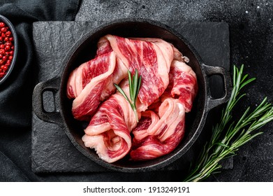 Raw bacon, strips of marbled meat in a pan. Black background. Top view - Powered by Shutterstock