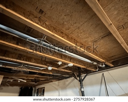 Raw basement structure with exposed timber beams and utility systems