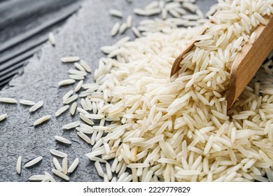 raw basmati rice on a black wooden background. - Shutterstock ID 2229779829