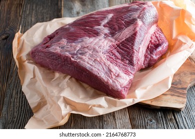 Raw Beef Brisket With Butcher Paper Isolated On Wooden Table 