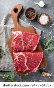 Raw beef chops on a cutting board. Animal product, red meat vertical photo