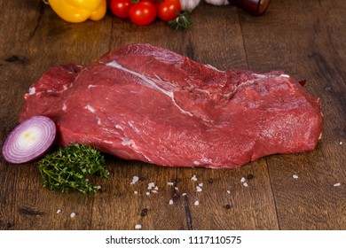 Raw beef meat over the wooden background