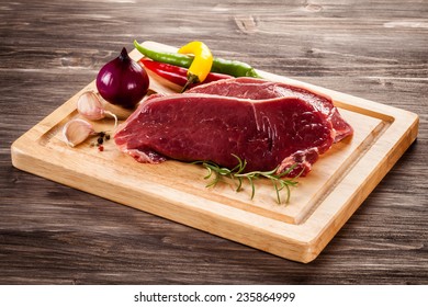 Raw Beef On Cutting Board And Vegetables