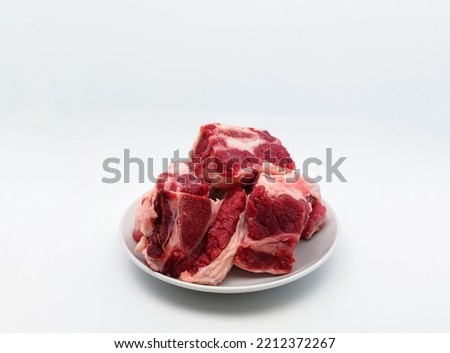 Raw beef ribs on a white plate. Isolated on white background with copy space.