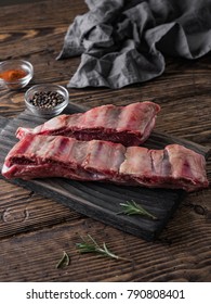 Raw Beef Ribs And Rosemary On Wooden Background