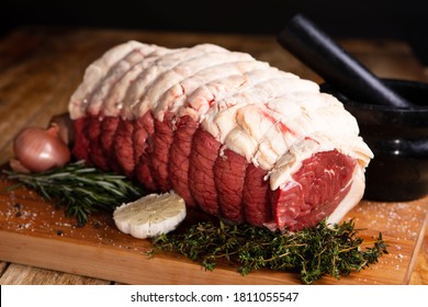 Raw Beef Sirloin Joint With Rosemary, Thyme, Garlic And Onion 