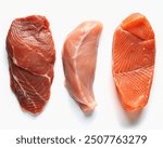 Raw beef steak, chicken breast, and salmon, isolated on white. Top view. Lean proteins