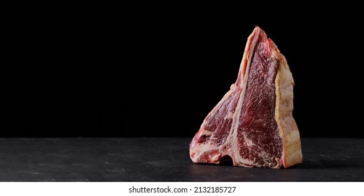 Raw Beef Steak, Dry Aged T Bone On Black Background. Free Space For Text