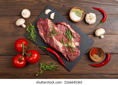 Raw Beef Steak On A Wooden Table. Healthy Food Concept. Beef Tenderloin And Spices For Making Hot Barbecue Sauce