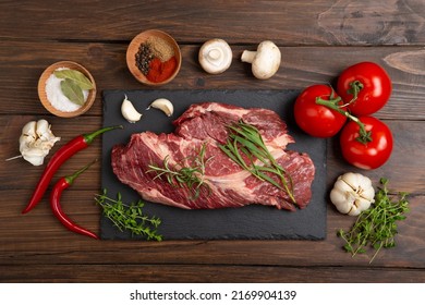 Raw Beef Steak On A Wooden Table. Healthy Food Concept. Beef Tenderloin And Spices For Making Hot Barbecue Sauce