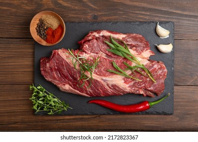 Raw Beef Steak On A Wooden Table. Healthy Food Concept. Beef Tenderloin And Spices For Making Hot Barbecue Sauce