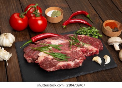 Raw Beef Steak On A Wooden Table. Healthy Food Concept. Beef Tenderloin And Spices For Making Hot Barbecue Sauce