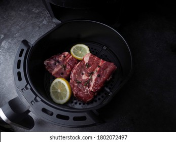 Raw Beef Steak With Rosemary, Salt,tomatoes,mushrooms In Air-fryer Machine.raw Fresh Meat With Vegetables Is Prepared Inside An Air Fryer Tray.