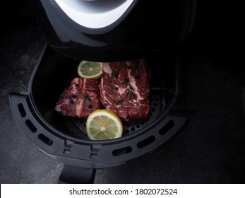 Raw Beef Steak With Rosemary, Salt,tomatoes,mushrooms In Air-fryer Machine.raw Fresh Meat With Vegetables Is Prepared Inside An Air Fryer Tray.