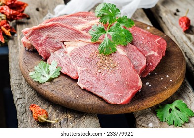 Raw beef steak with spice on wooden plate and wooden background - Powered by Shutterstock