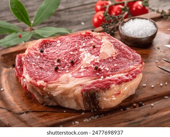 Raw beef steaks with herbs and spices ready for cooking are on wooden board. - Powered by Shutterstock