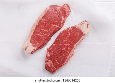 Raw Beef Striploin Steak. Two Strip Loin Steaks On White Table. Fresh Meat. Close Up. Top View.